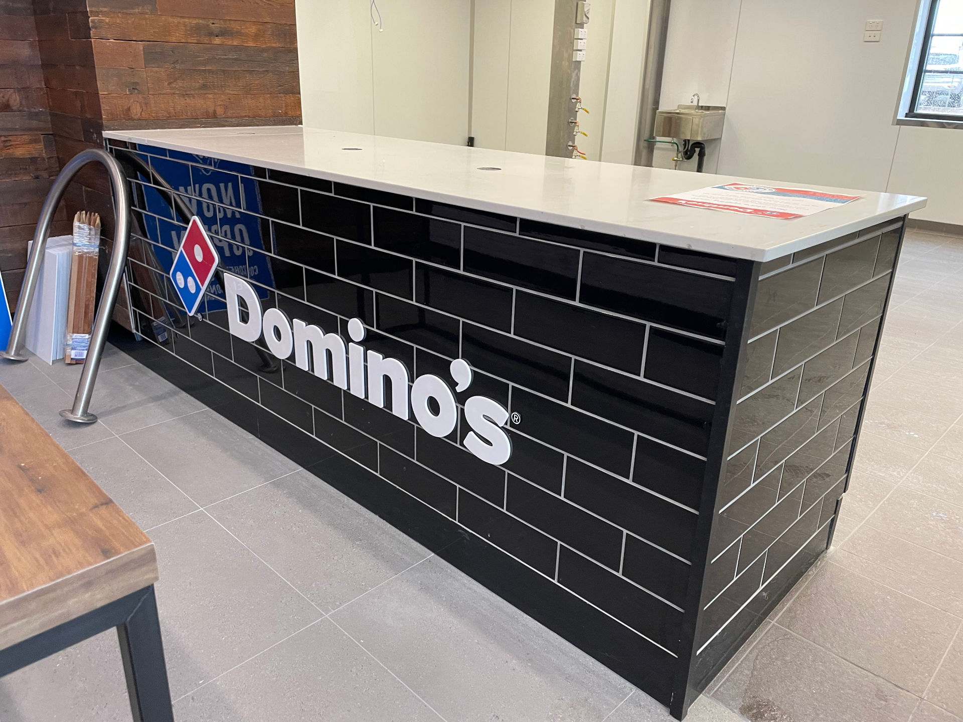 Dimensional Domino's lettering on tiled counter